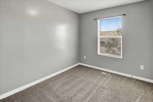 Empty room with dark carpet and baseboards