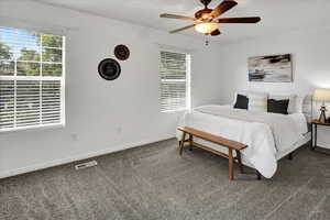 Carpeted bedroom featuring baseboards and a ceiling fan