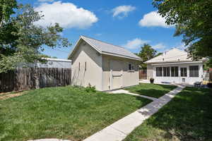 Rear view of property with a storage unit, a sunroom, and a shingled roof