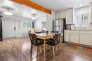 Dining room featuring a textured ceiling, beam ceiling, and light wood-style flooring
