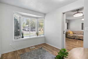 Empty room with a textured ceiling and wood finished floors