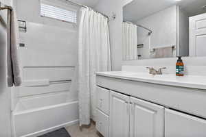 Bathroom with vanity, shower / bath combination with curtain, and tile patterned floors