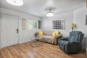 Living area featuring a textured ceiling and wood finished floors