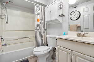Bathroom featuring shower / tub combo with curtain, vanity, and tile patterned flooring