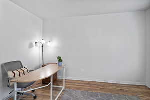 Office space with wood finished floors and a textured ceiling
