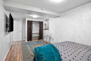Bedroom featuring a textured ceiling and wood finished floors
