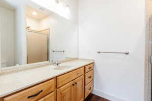Bathroom featuring vanity, a shower stall, and wood finished floors