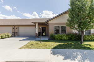 Ranch-style house featuring an attached garage, concrete driveway, a front yard, and roof with shingles