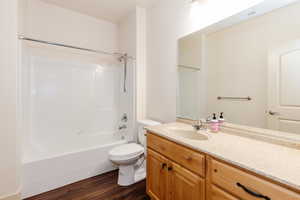 Full bath featuring vanity, wood finished floors, and bathtub / shower combination