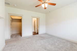 Unfurnished bedroom featuring carpet, a spacious closet, and ceiling fan