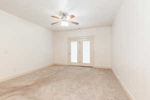 Spare room with light colored carpet and a ceiling fan