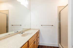 Full bath featuring vanity, a shower stall, and wood finished floors
