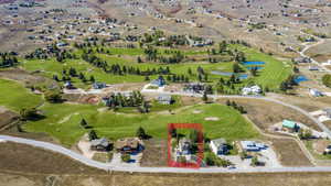 Aerial view of property's location with property boundaries highlighted, a golf course, and a nearby body of water