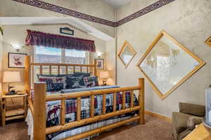 Carpeted bedroom with baseboards and wallpapered walls