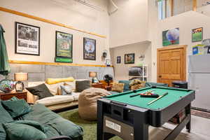 Recreation room with billiards and a high ceiling
