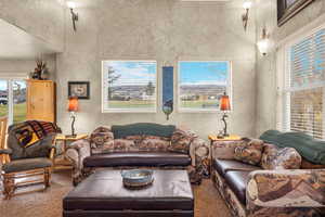Living room with carpet flooring and a towering ceiling