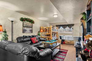 Carpeted living area featuring a textured ceiling