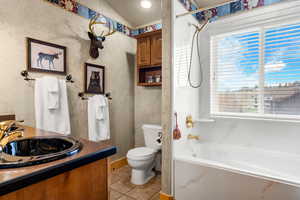 Bathroom featuring vanity, light tile patterned floors, healthy amount of natural light, shower / bathtub combination with curtain, and lofted ceiling