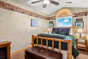 Bedroom featuring lofted ceiling, a ceiling fan, and carpet