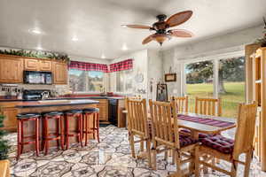 Dining room with a textured ceiling, recessed lighting, and a ceiling fan.