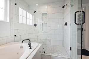 Full bath featuring a stall shower and a tub with jets