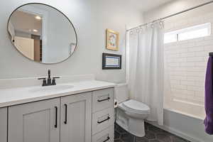 Full bathroom with vanity, shower / bath combination with curtain, and tile patterned flooring