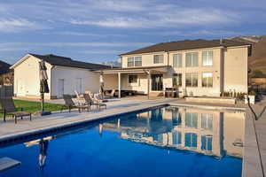 Back of house with a patio and an outdoor pool