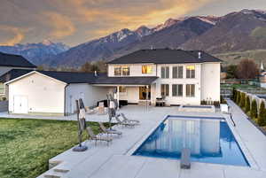 Back of house with a fenced backyard, a mountain view, and a patio area