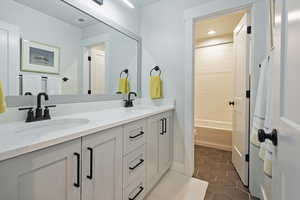 Bathroom featuring double vanity, tile patterned floors,  shower combination, and recessed lighting