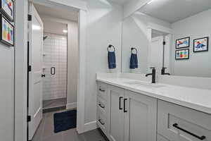 Bathroom with a shower stall, vanity, and tile patterned flooring
