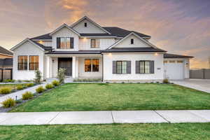 Modern farmhouse featuring board and batten siding, driveway, a porch, and a garage