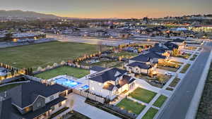 Aerial view at dusk of a residential view, view of pool area, and a mountain view