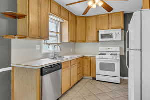 Kitchen featuring white appliances, ceiling fan, light countertops, and light tile patterned floors