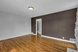 Spare room featuring wood finished floors and baseboards
