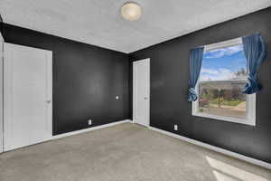 Spare room with a textured ceiling and carpet flooring