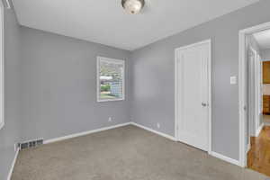 Unfurnished bedroom featuring baseboards and carpet floors