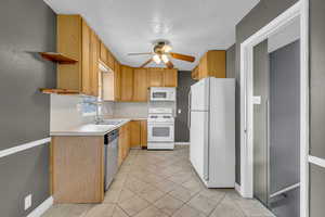 Kitchen featuring white appliances, ceiling fan, light countertops, a textured ceiling, and open shelves