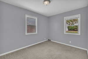 Carpeted empty room featuring baseboards