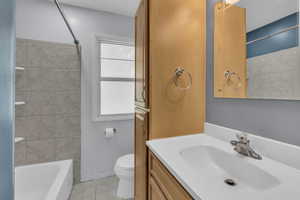 Bathroom with vanity, shower / bathtub combination, and tile patterned floors