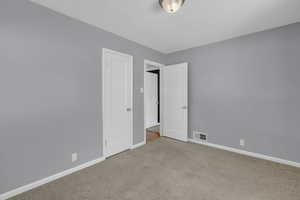 Empty room featuring carpet floors and baseboards
