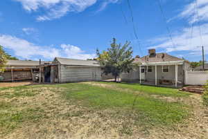 Back of house with a fenced backyard and a patio area