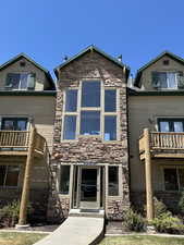 View of front of home featuring stone siding and a balcony