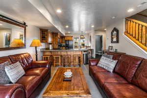 Carpeted living room with a textured ceiling, a barn door, and recessed lighting