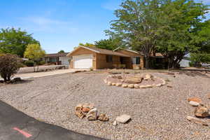 Ranch-style home with concrete driveway, an attached garage, stucco siding, and brick siding