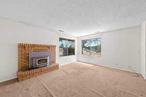 Unfurnished living room with a textured ceiling and carpet flooring