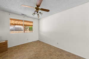 Spare room featuring a textured ceiling and a ceiling fan