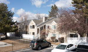 View of front facade with uncovered parking, a chimney, a shingled roof, a residential view, and stairway