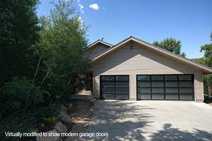 View of front of home with a garage and concrete driveway