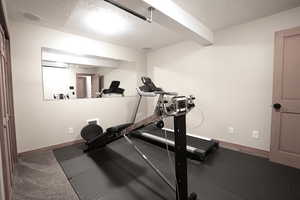 Exercise area featuring a textured ceiling and baseboards