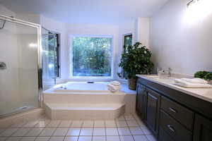 Full bathroom featuring tile patterned floors, a shower stall, a garden tub, and vanity